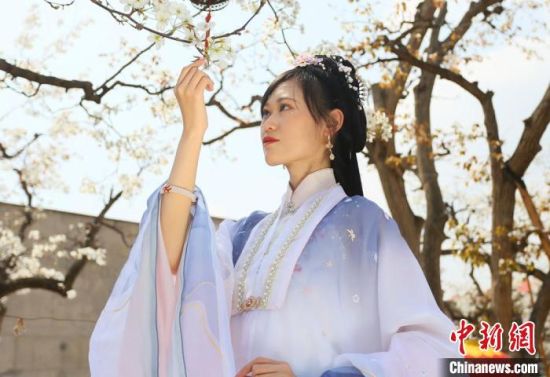 圖為蘭州青年身穿漢服在百年梨園賞景?！「哒?攝