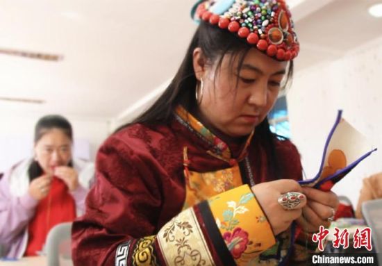圖為裕固族婦女學(xué)習(xí)刺繡?！∈缝o靜 攝