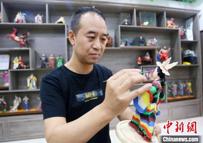 圖為安秋平正在創(chuàng)作代表隴南文縣民俗的《白馬人》作品?！「哒?攝