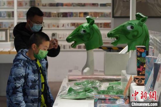 圖為“神馬來了”銅奔馬頭套吸引參觀者駐足?！【琶赖┰?攝