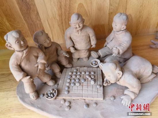 圖為泥塑作品展現下棋場景。 劉玉桃 攝