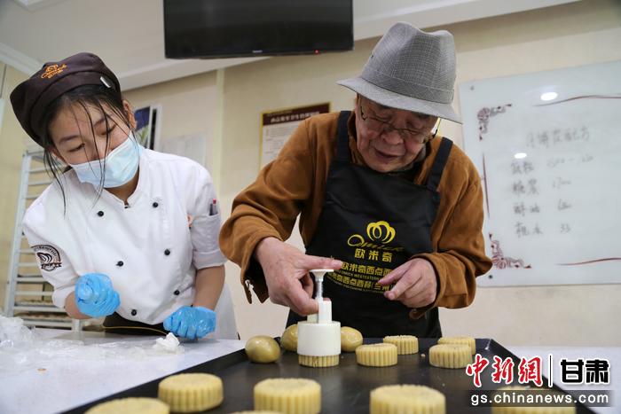 當日，受邀參加活動的臺胞臺屬代表、兩岸婚姻及子女、在甘臺商代表等歡聚一堂。圖為77歲的在甘臺胞潘天鑒制作月餅。九美旦增 攝