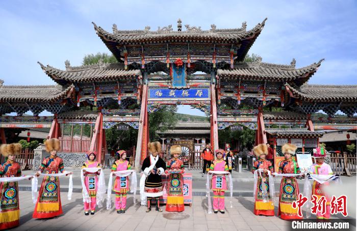 圖為身穿土族服飾的工作人員迎接訪(fǎng)客?！⊙Φ?攝