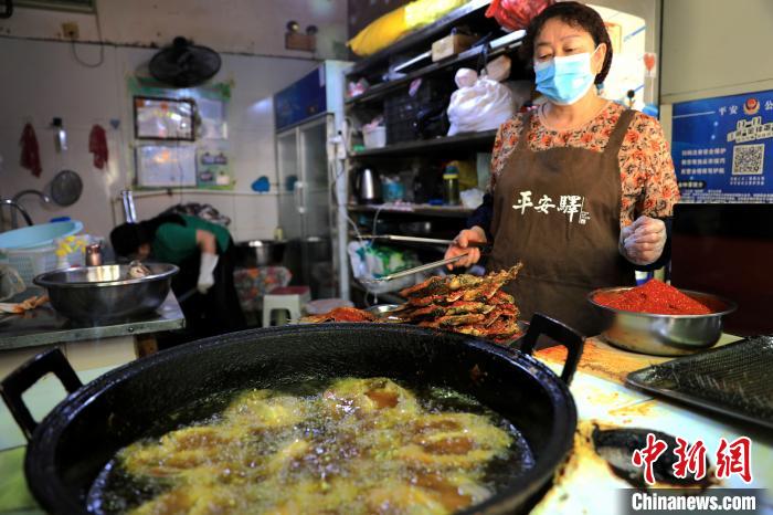 圖為平安驛·河湟民俗文化體驗(yàn)地內(nèi)的商戶(hù)炸干板魚(yú)?！⊙Φ?攝