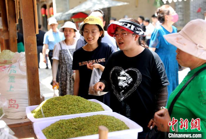 圖為民眾購(gòu)買(mǎi)青海特色小吃?！⊙Φ?攝