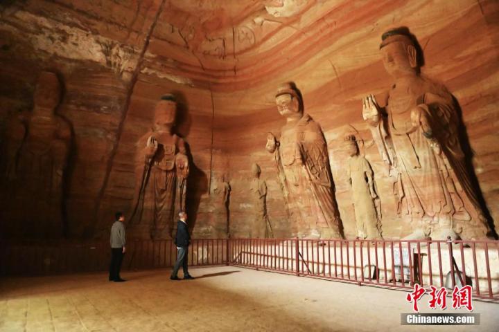 7月15日，游人參觀甘肅省平?jīng)鍪袥艽h百里石窟長廊中的南石窟寺1號窟。百里石窟長廊位于涇川縣境內(nèi)，由512個石窟、5眼窟中石井組成，現(xiàn)存王母宮石窟、鳳凰山石窟、南石窟寺、丈八寺石窟、羅漢洞石窟、太山寺石窟等規(guī)模較大的石窟群，還有數(shù)量眾多的小石窟群。南石窟寺開鑿于北魏永平三年，其中1號窟屬于大型七佛窟，七佛高達6米。中新社記者 李亞龍 攝